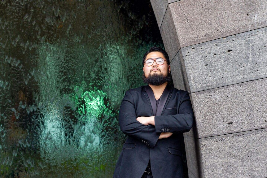 Artist Badiucao stands in front of the National Gallery of Victoria