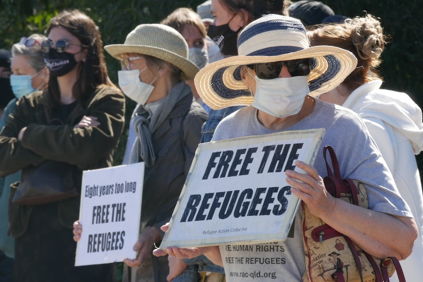 Protesters hold signs that read 'free the refugees'.