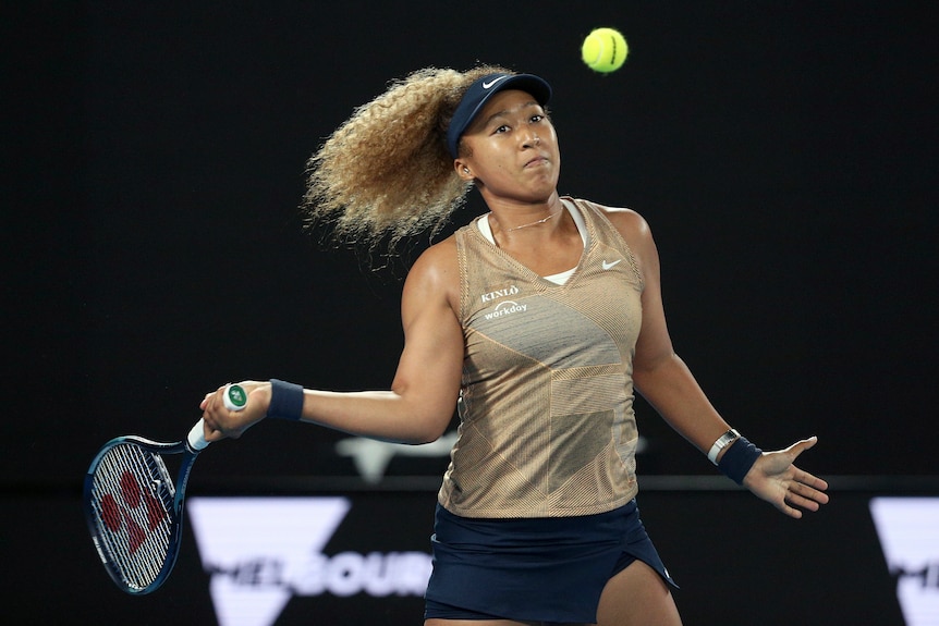 Japan's Naomi Osaka holds a tennis racket and hits a tennis ball in the air