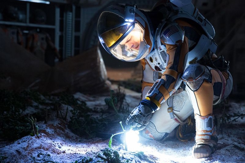 Scene from the Martian with Mark Watney in dark near potatoes.