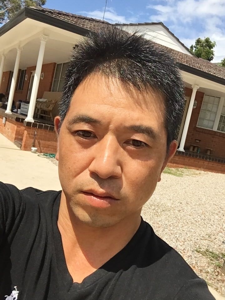 一个男人站在一栋房子前面。