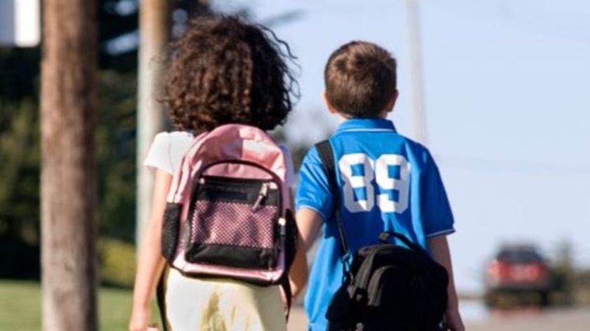 Two primary school-aged students walking home after school.