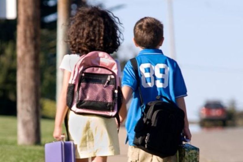 Two primary school-aged students walking home after school.