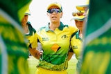 Ashleigh Gardner stands arm in arm with teammates in the Australian Indigenous women's cricket team.