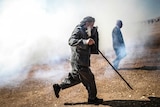 Old Kurdish man runs away from tear gas near Turkish-Syria border crossing