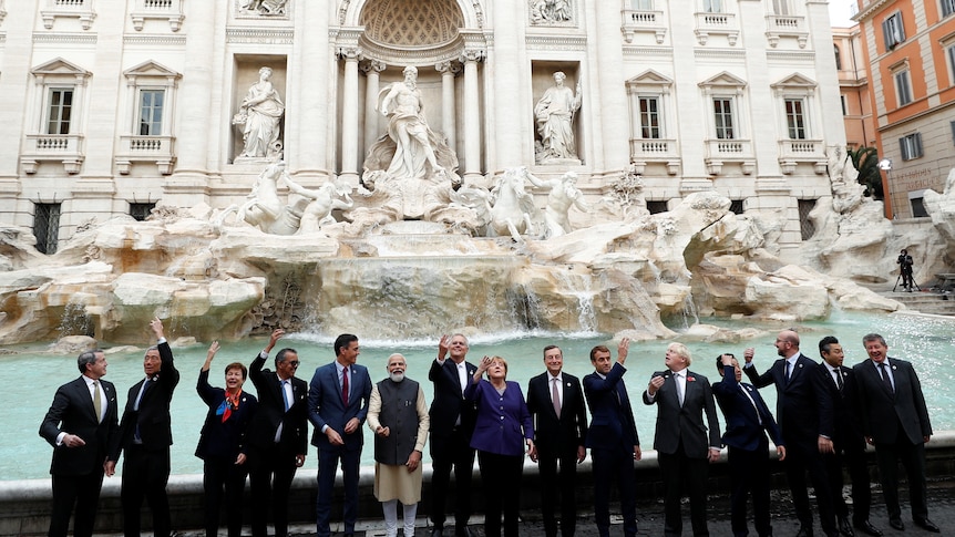 G20 leaders stand in a row in front of Rome's iconic Trevi Fountain on the last day of the G20 summit.