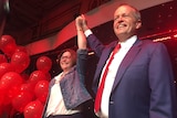 Ged Kearney and Bill Shorten smile and hold their hands in the air.