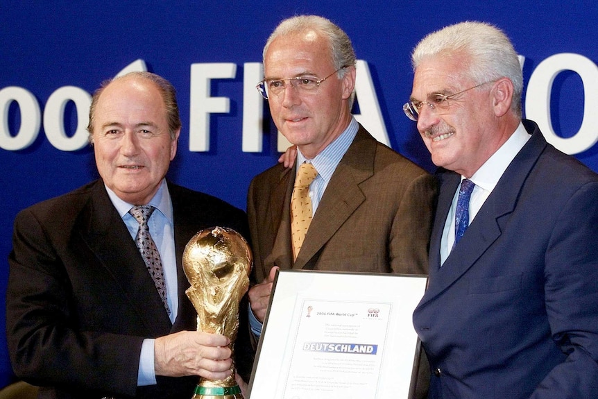 FIFA president Sepp Blatter (L) with the World Cup, Franz Beckenbauer (C) and Fedor Radmann (R).