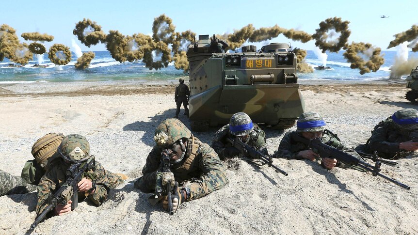 Marines from the US and South Korea take positions on a beach after landing in joint military exercises.