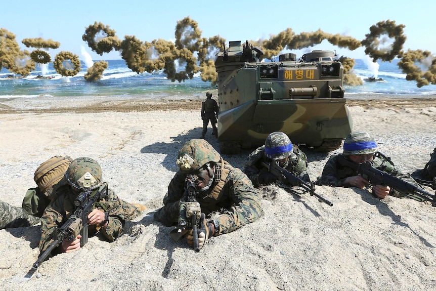 Marines from the US and South Korea take positions on a beach after landing in joint military exercises.