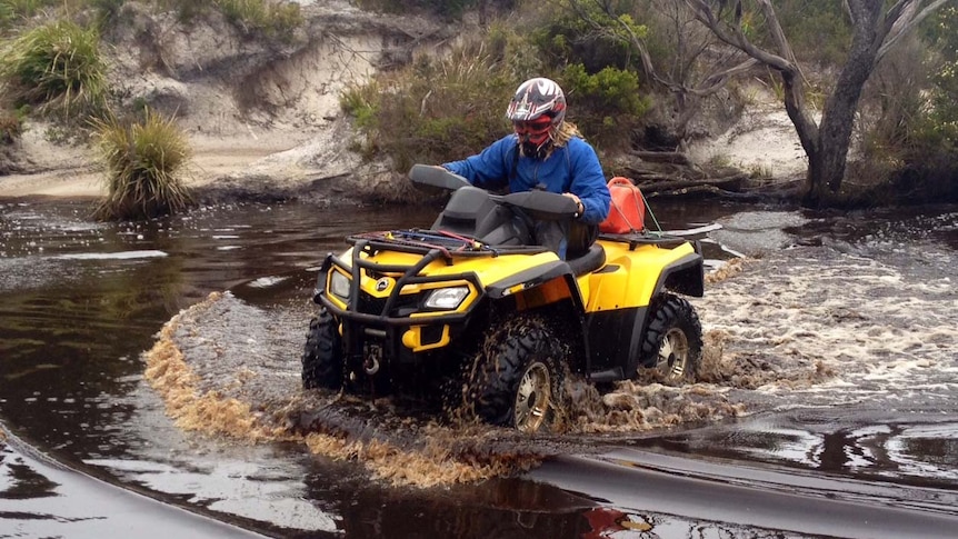 A quad bike is ridden through a river on Tasmania's west coast.