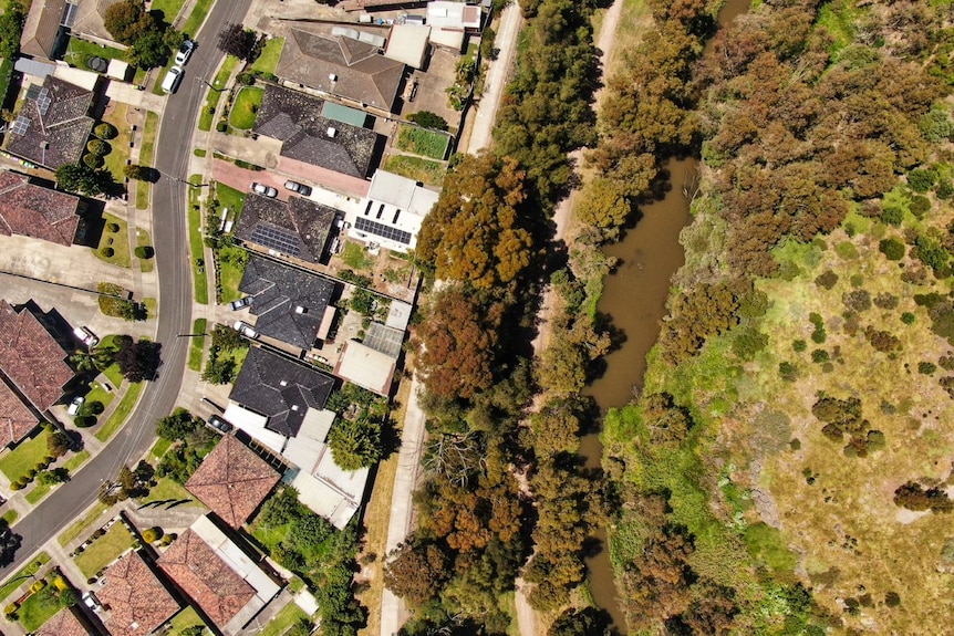 A drone picture showing a residential street sitting next to Kororoit Creek and parkland