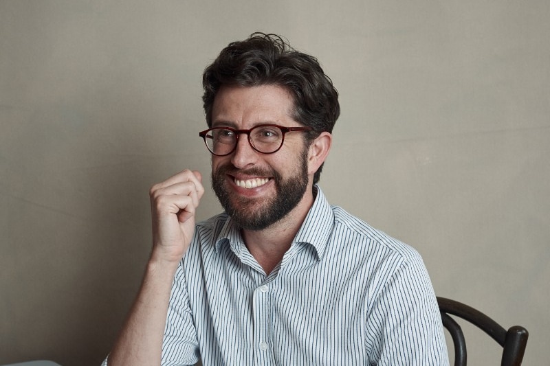 Ben McAlpine in glasses and a striped shirt with a beard