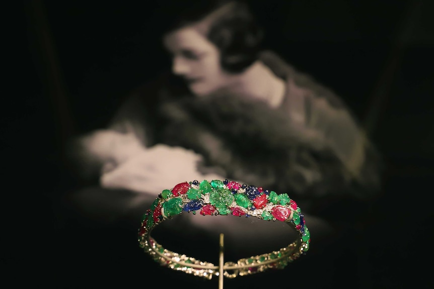 Tutti Frutti bandeau made up of emeralds, rubies, sapphires and diamonds with a picture of Lady Mountbatten in the background.