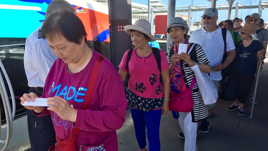 Chinese tourists line up for a cruise in Cairns.