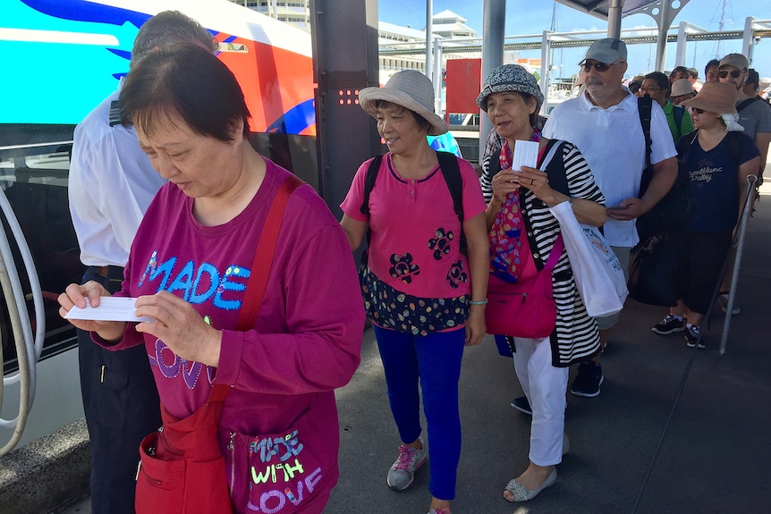 Chinese tourists line up for a cruise in Cairns.