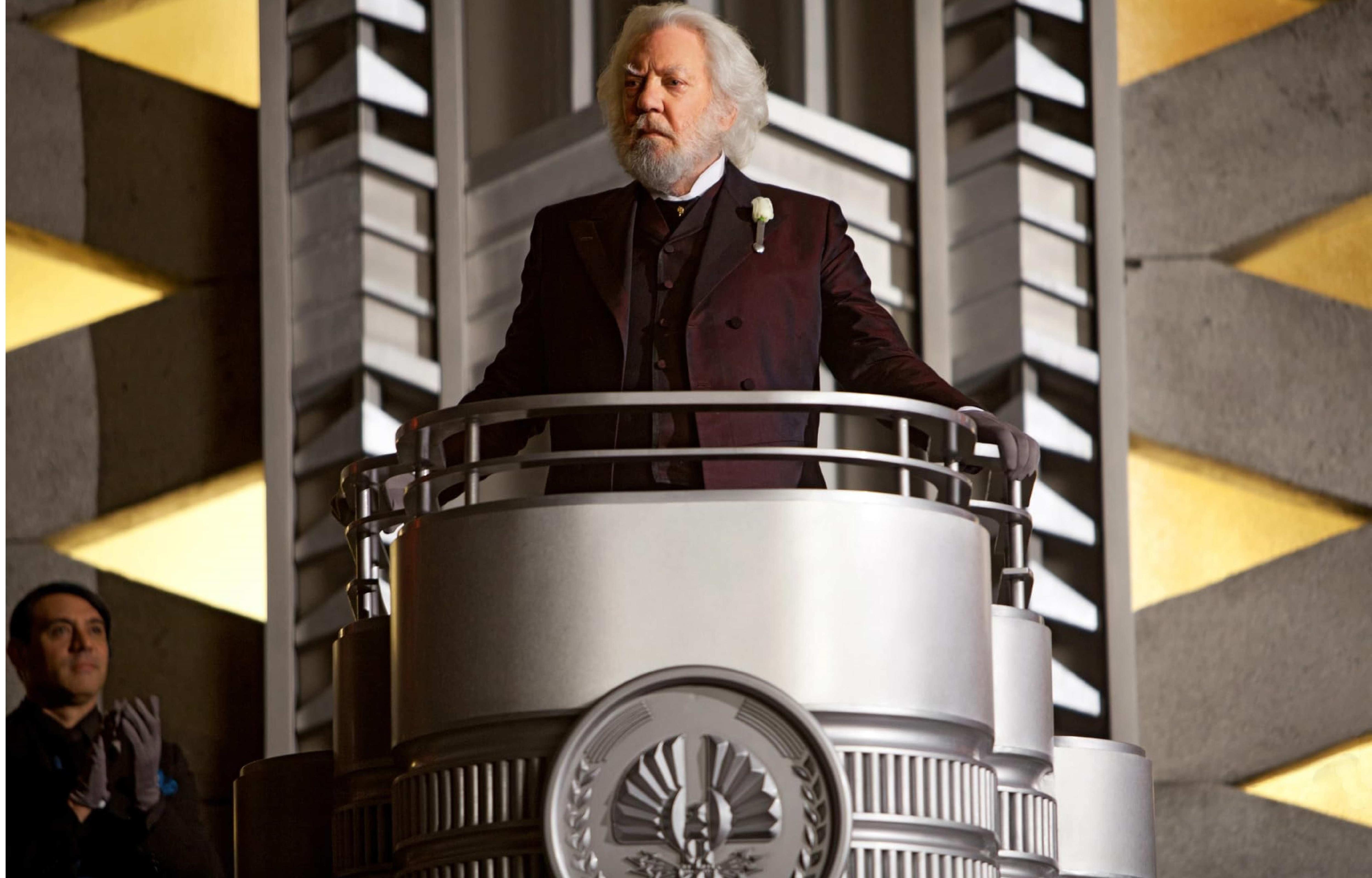 Donald Sutherland as President Snow standing and addressing the people