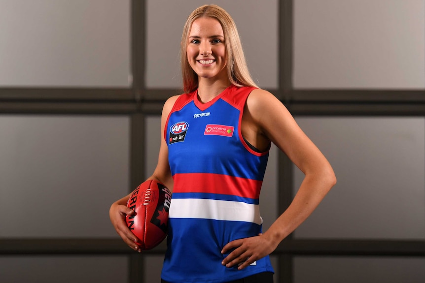 A women's Aussie Rules footballer smiles after being named as AFLW number one draft pick.