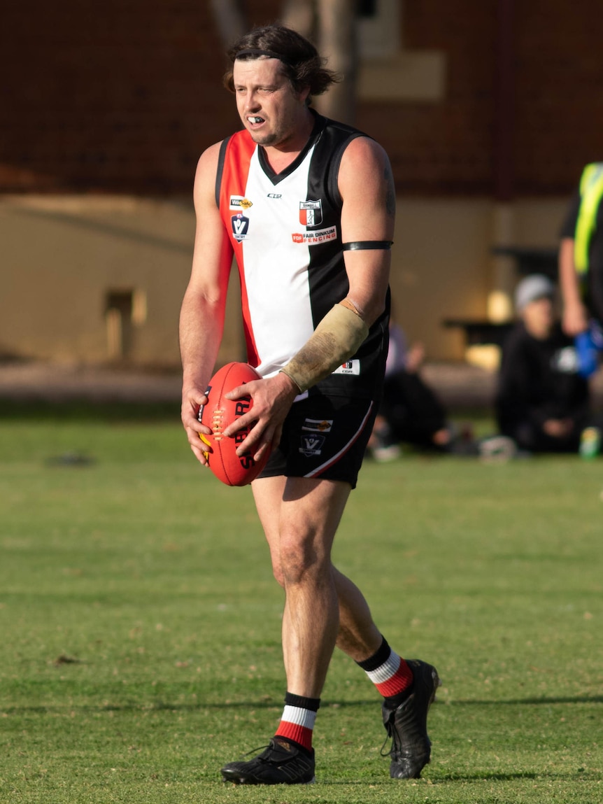 A footballer lines up for goal.