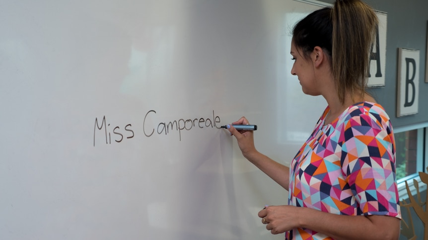 Anita Camporeale writes her name on a smartboard.