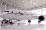 A large plane sits in a hangar with Fuerza Aerea Mexicana written on the side