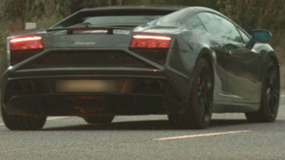 A dark-coloured supercar – a Lamborghini Gallardo – seen from behind.