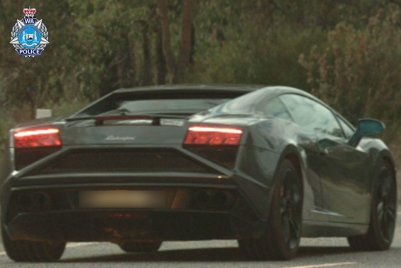 A dark-coloured supercar – a Lamborghini Gallardo – seen from behind.