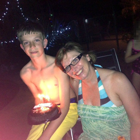 Rosie Batty sits next to her son Luke, who holds a birthday cake.