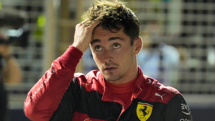 Ferrari driver Charles Leclerc runs his hand through his hair as he looks up at the scoreboard after F1 qualifying.