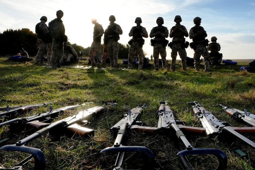 - Weapons lie on the ground as Ukrainian personnel take a break during training at a military base with UK Armed Forces.