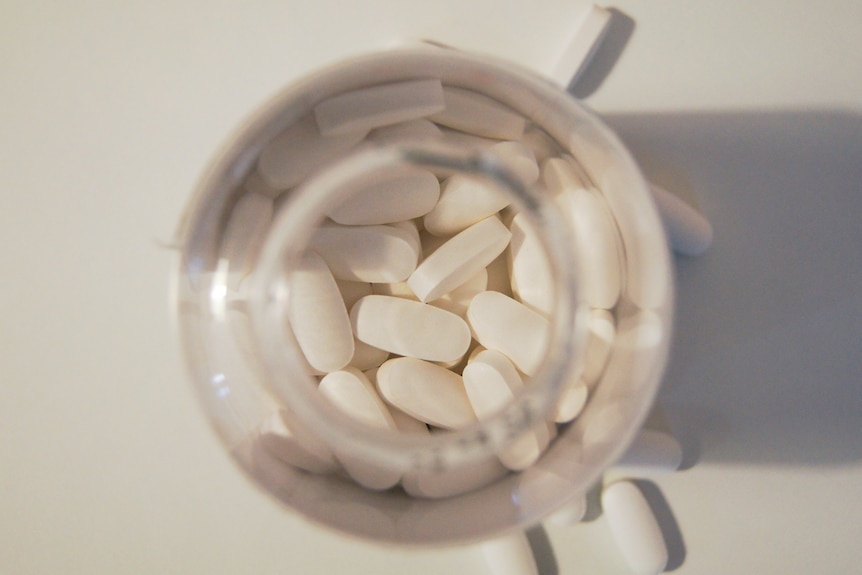 a clear bottle filled with white tablets