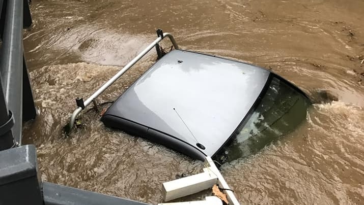 Top of a ute poking up through brown floodwater