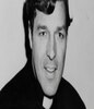 乔治佩尔穿着牧师装微笑的黑白照片。