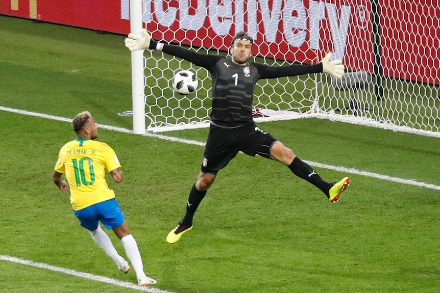 Serbia goalkeeper spreads arms wide to save shot by Neymar