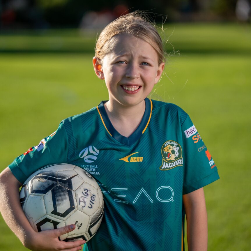 Lilly Storrie holds a soccer ball.