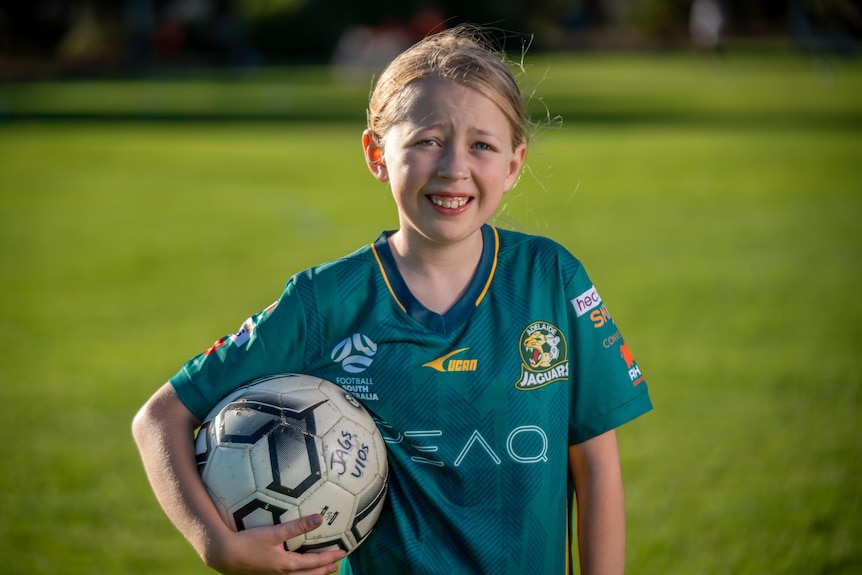 Lilly Storrie holds a soccer ball.