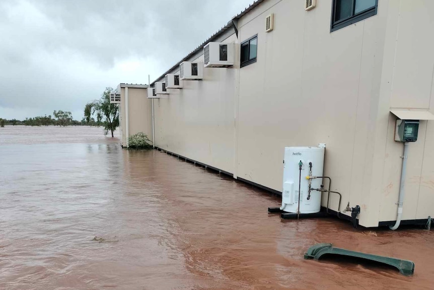 brown floodwaters rising against demountable pods 