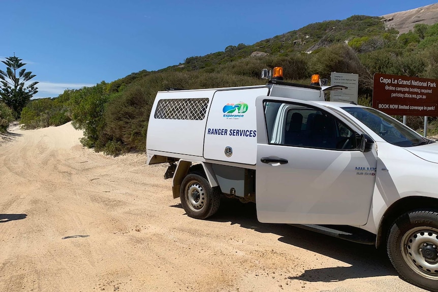 A ranger van parked on a gravel road.