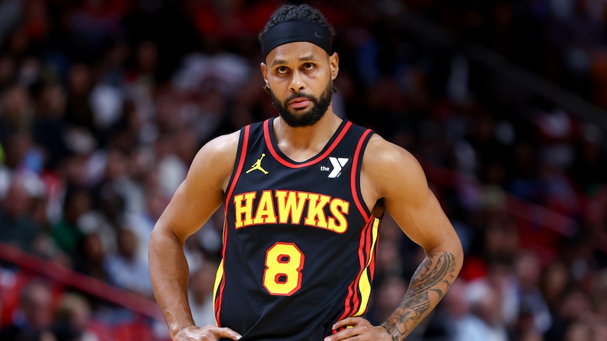 Patty Mills stands with his hands on hips during an NBA game for the Atlanta Hawks.