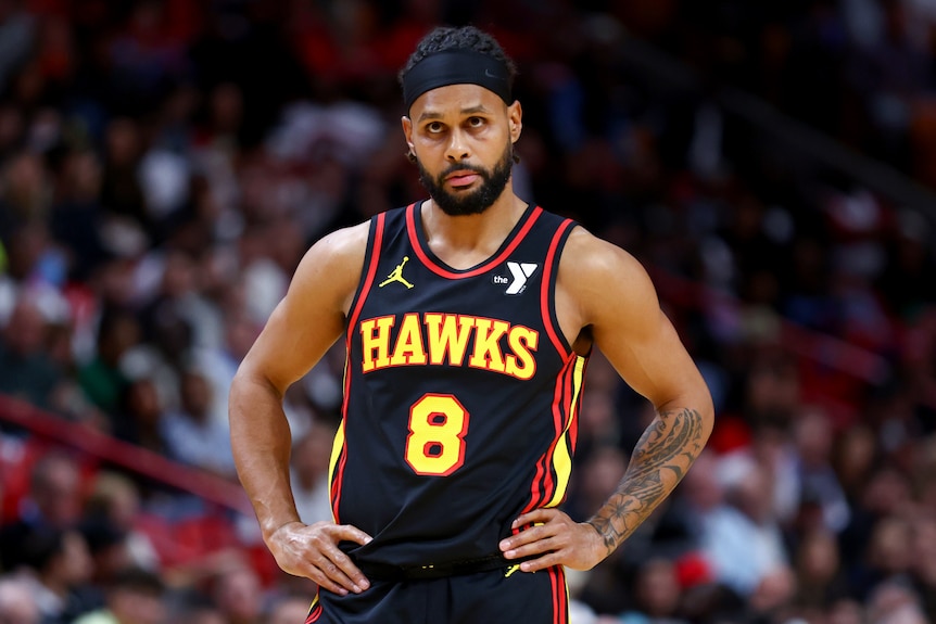 Patty Mills stands with his hands on hips during an NBA game for the Atlanta Hawks.