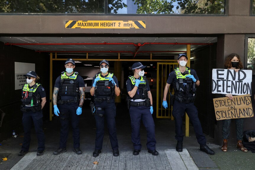 Police officers stand guard outside Novak Djokovic's hotel in Melbourne.