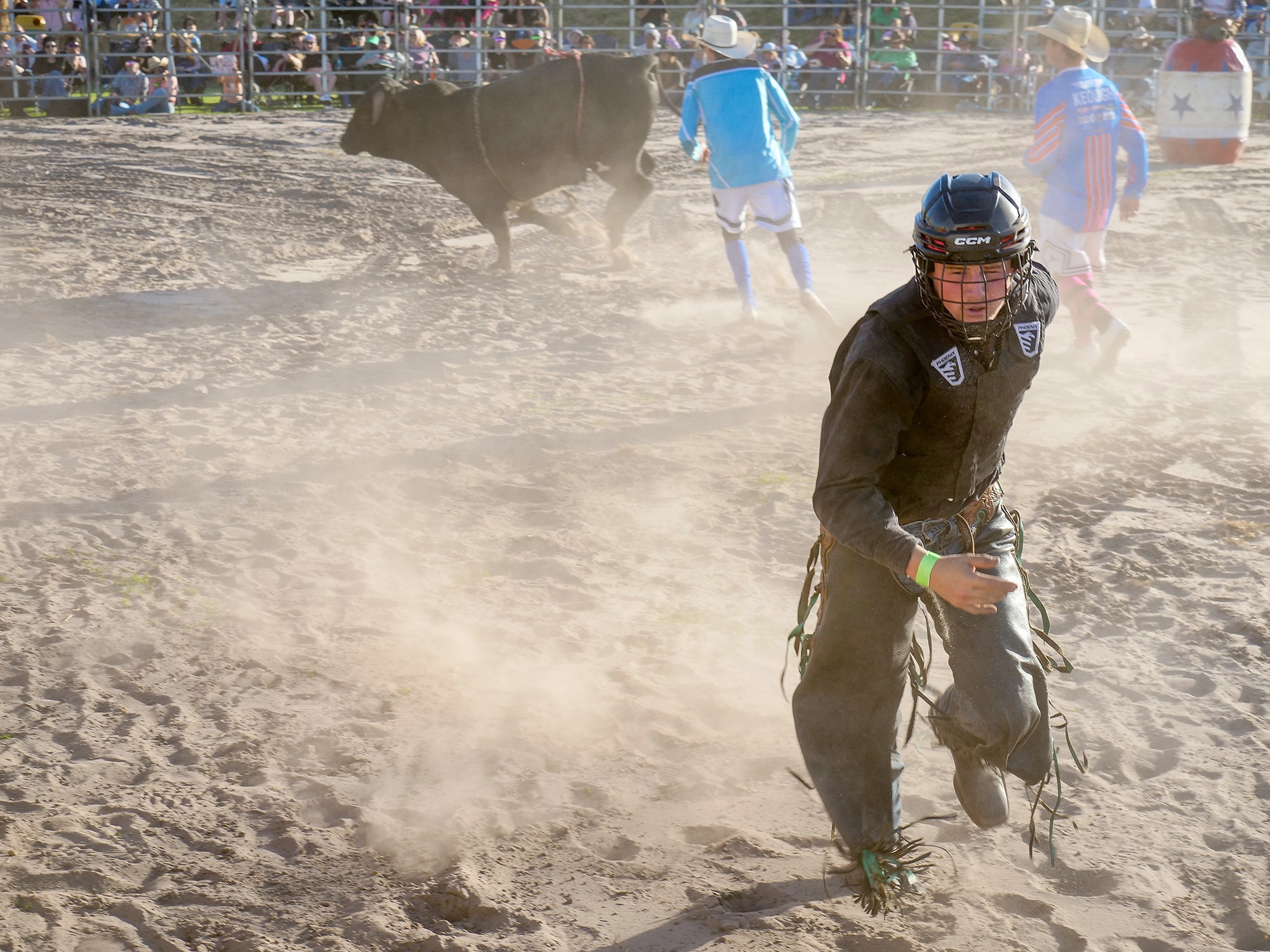 A man runs from a ball in a ring. 