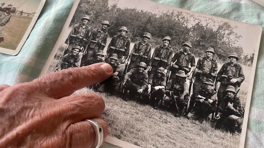 Someone points to a solider in an old photograph.