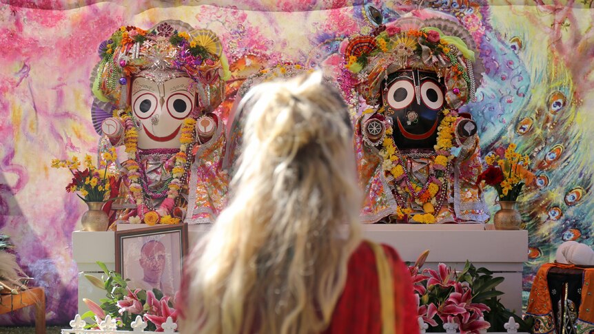 Hare Krishna devotee worships at altar