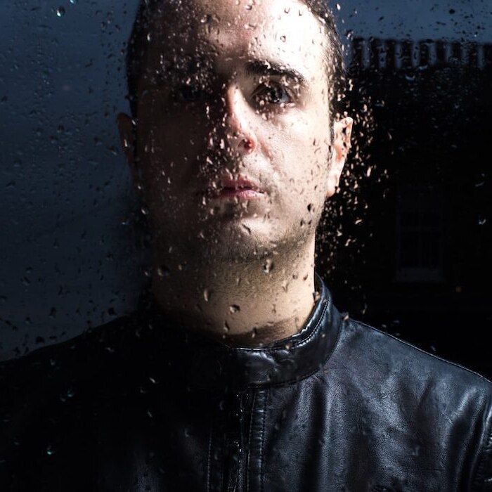A photo of DJ Piero Pirupa behind glass with condensation on it