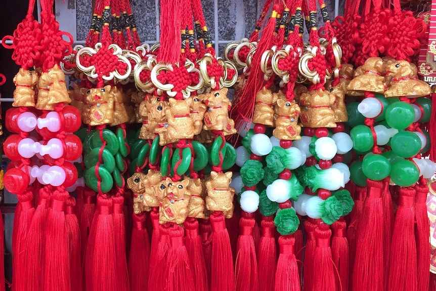 Decorations show small dogs with green and red beads and red tassels.