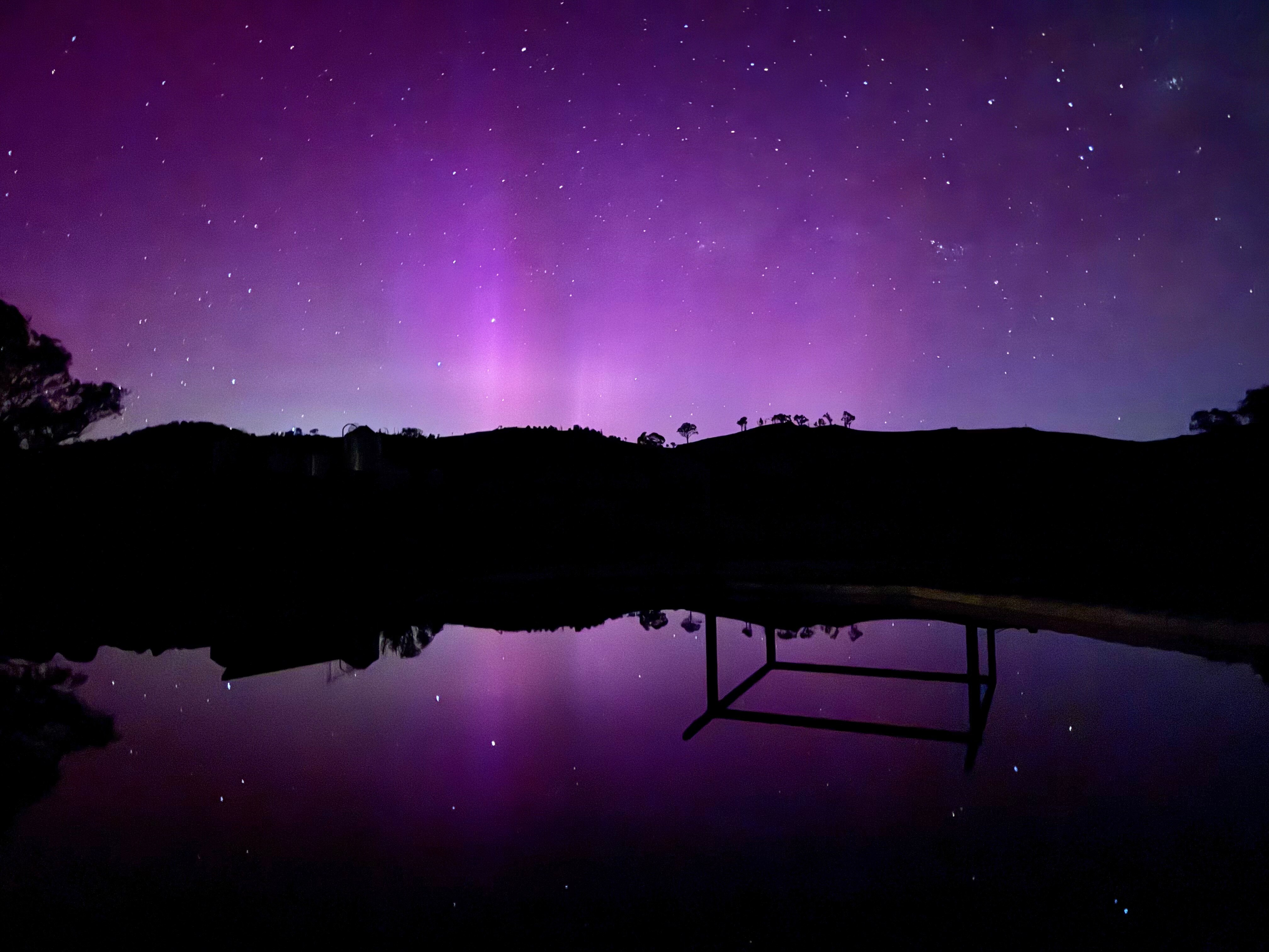 Um céu violeta à noite com as montanhas ao fundo.
