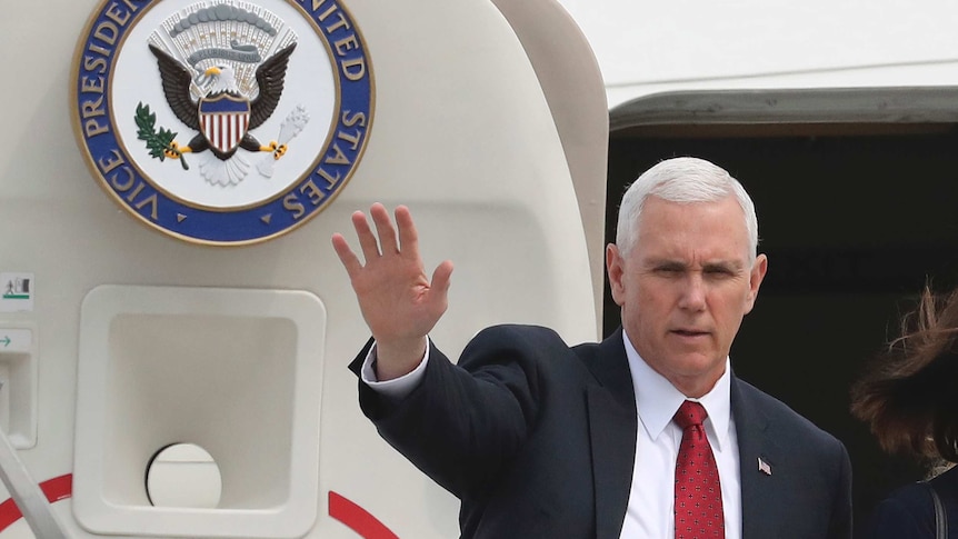 US Vice-President Mike Pence waves with his right hand as he disembarks his aircraft in South Korea, April 18, 2017.