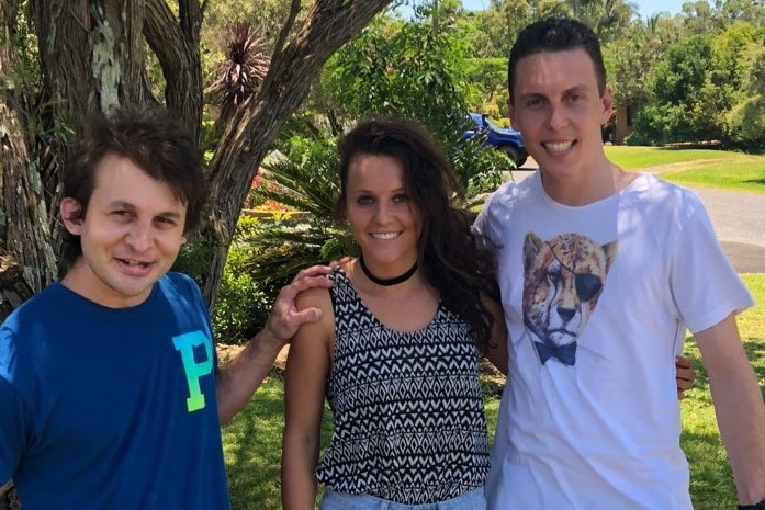 Hayley Raso stands in between her brothers in front of a tree.