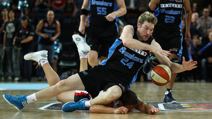 Tight contest ... Dillon Boucher of the Breakers trips over Damian Martin of the Wildcats during game one